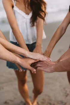 amigos-juntando-manos-playa